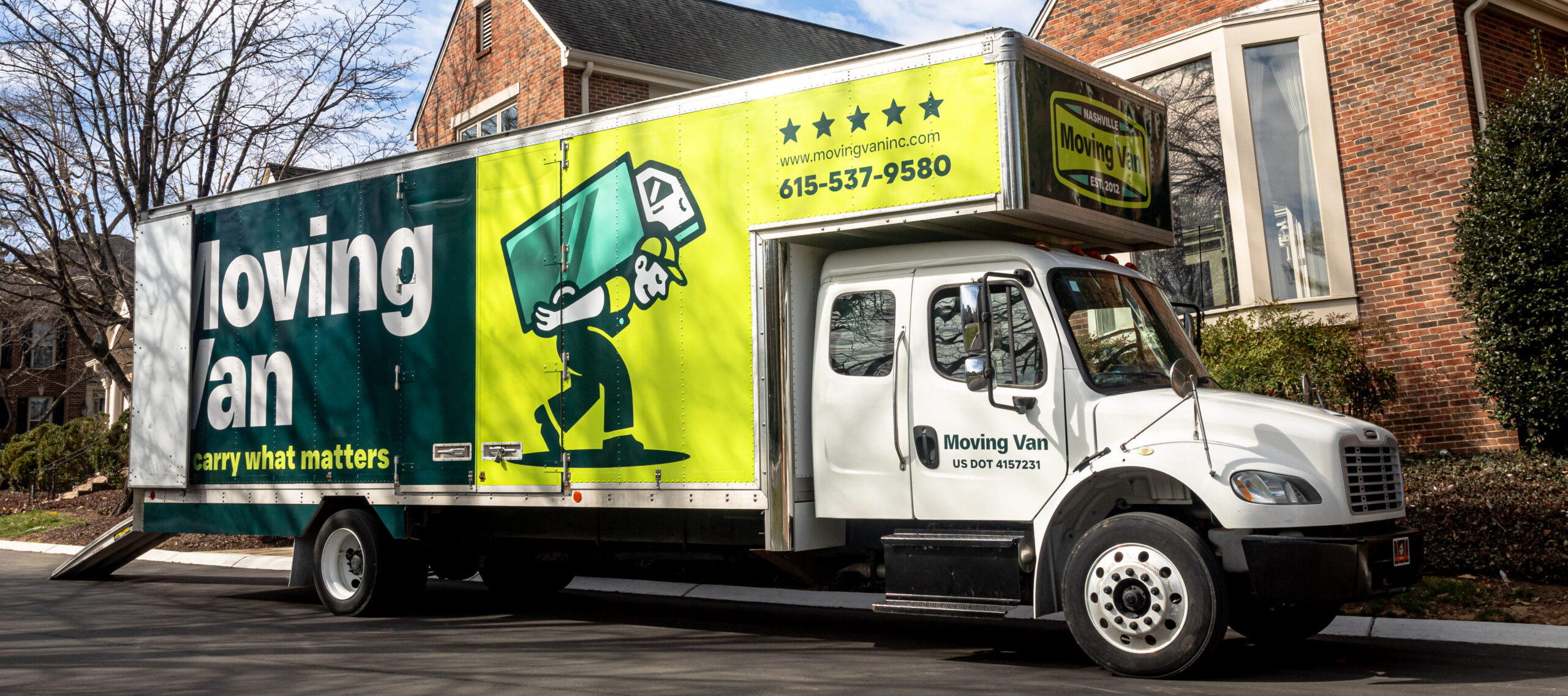 residential-moving A large white moving van with green and yellow branding is parked on a suburban street. The van features bold text and a cartoon figure, giving a professional and approachable impression.
