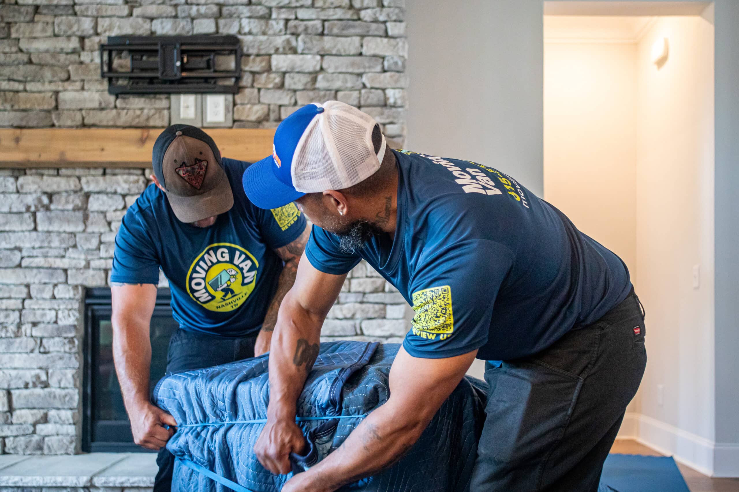 Two Moving Van movers packing furniture.